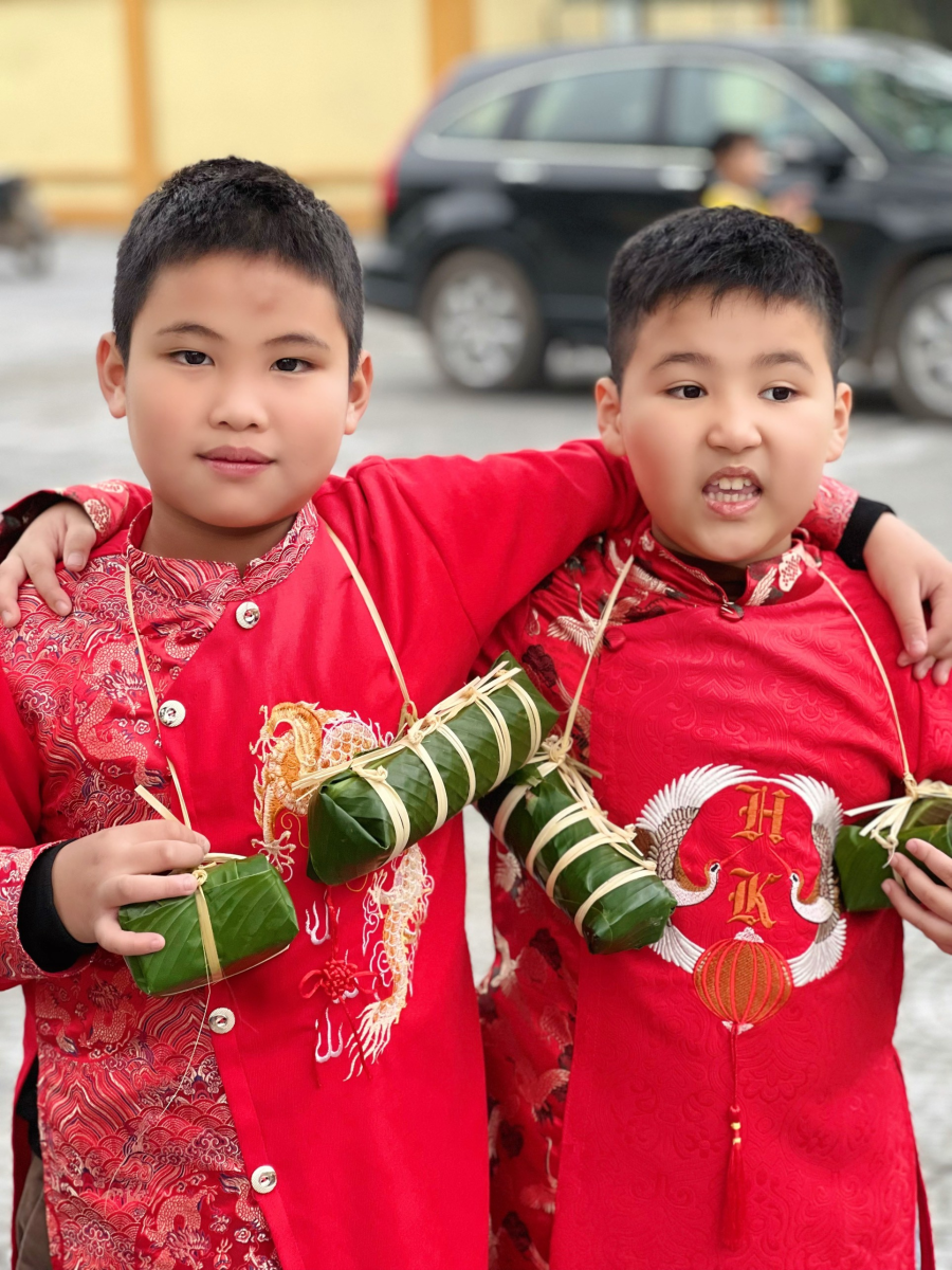A pair of young boys wearing red shirts  Description automatically generated